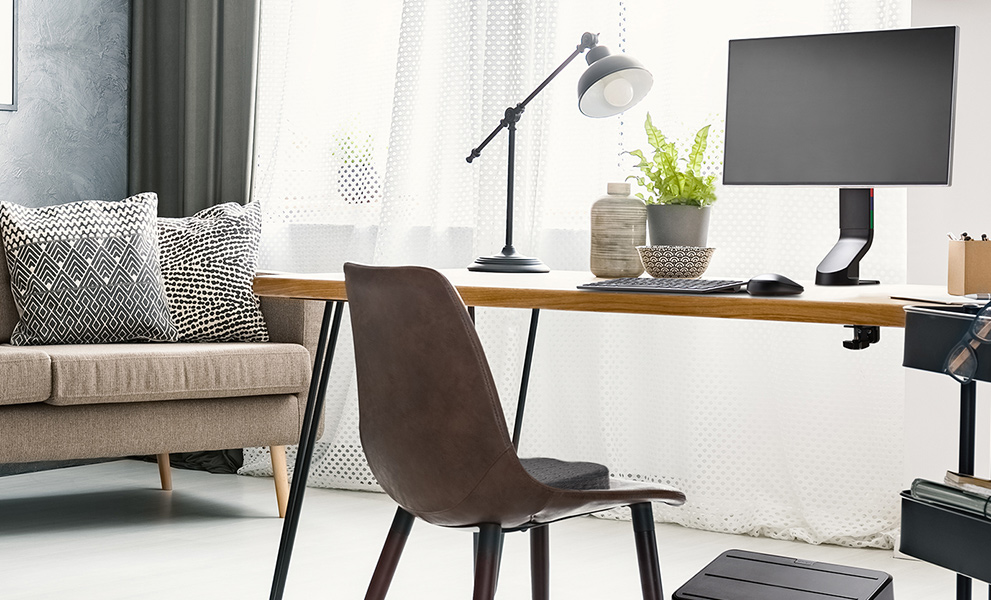 Ergonomic home office desk setup with Kensington keyboard, mouse, monitor arm, and foot rest.