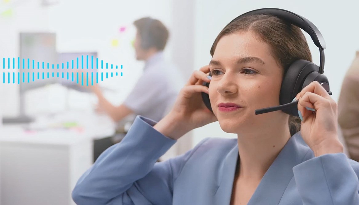 Woman smiling and putting on a Kensington headset.