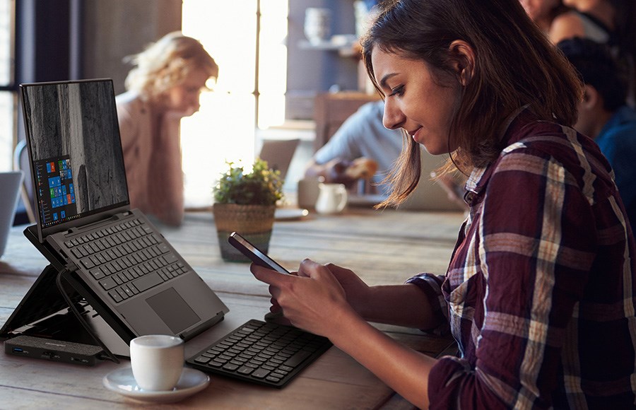 a woman at a cafe using a mobile docking station to set up her laptop with ease.