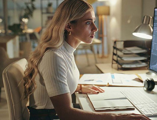 woman looking intently at a large computer screen.